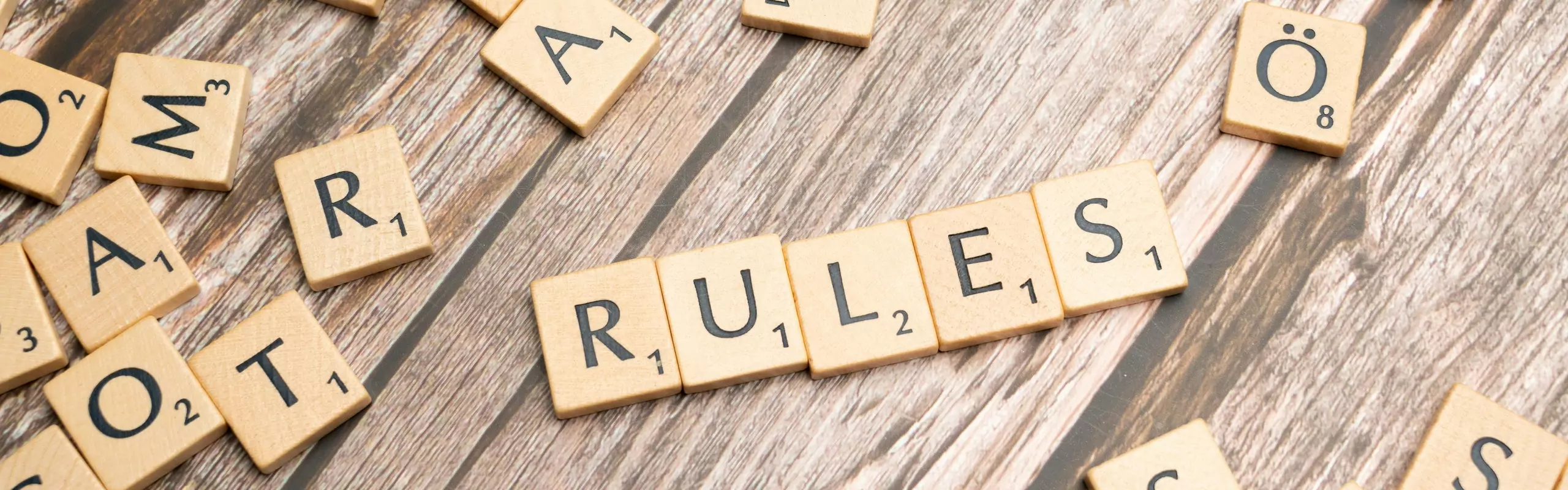 Scrabble letters spelling rules on a wooden table